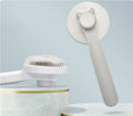 Gray pet grooming brush with a round pin head and plastic handle