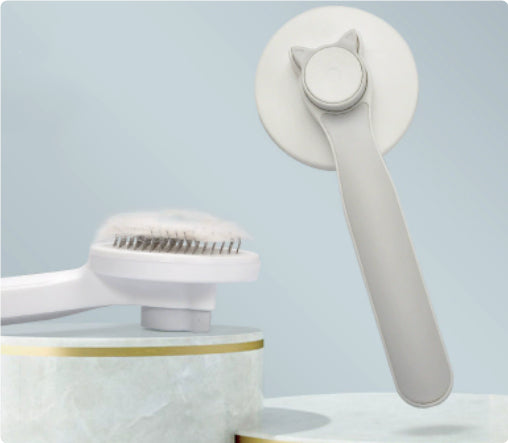 Gray pet grooming brush with a round pin head and plastic handle